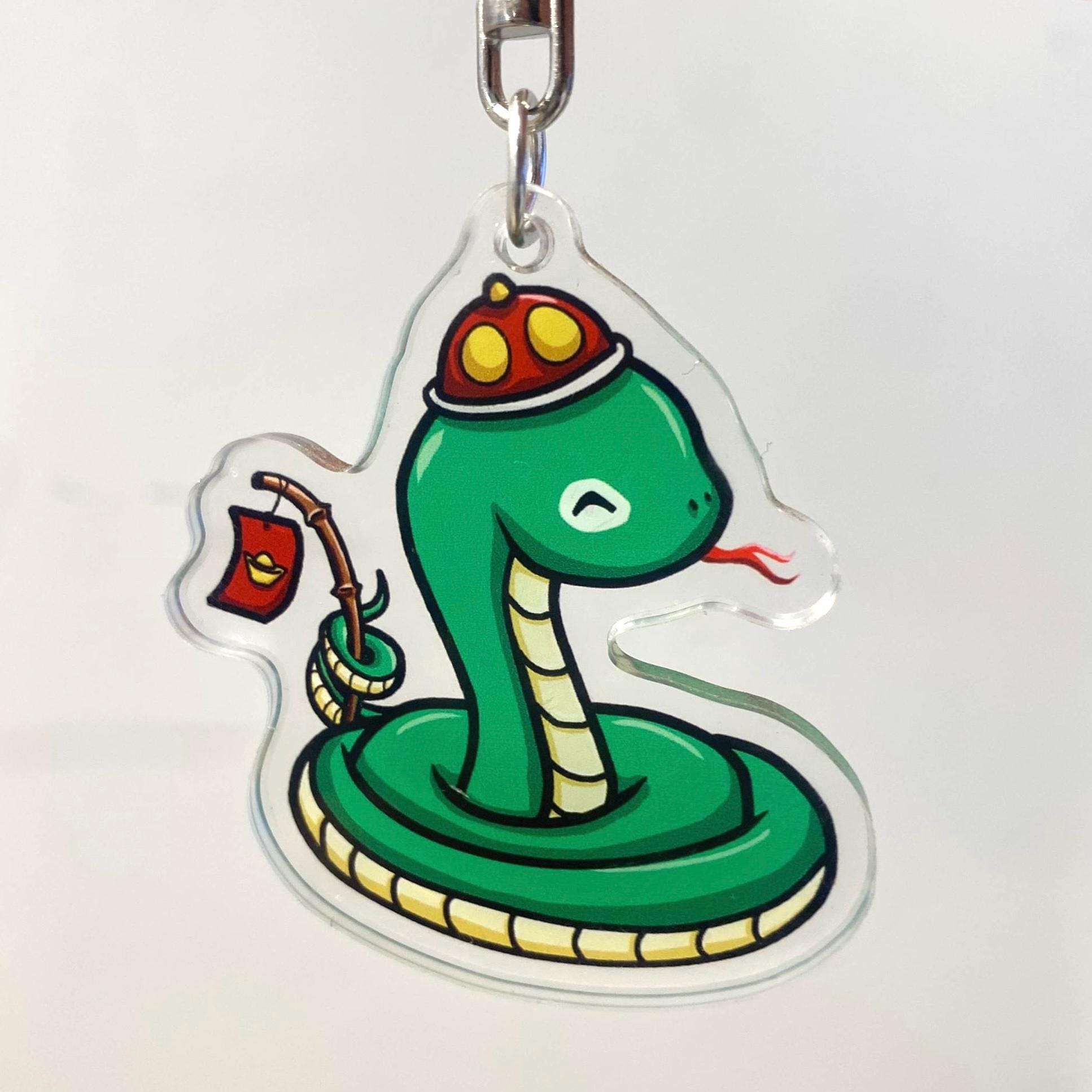 Acrylic Year of the Snake Wearing Hat Holding a stick with a Red Li Xi Envelope Cute Keychain